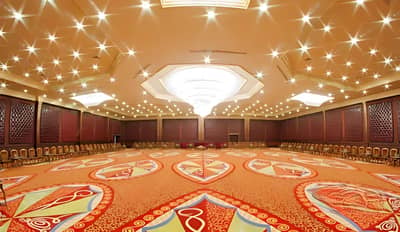 Spacious ballroom with ornate carpet at Regency Hall Doha.