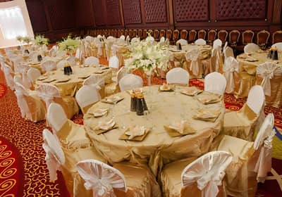 Elegant banquet setup at Regency Hall Doha with gold tablecloths.