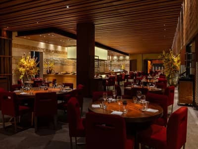 Elegant dining area at Zuma Restaurant Doha with red chairs.