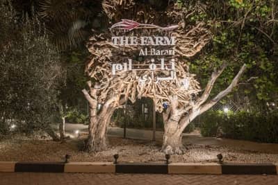 Entrance sign of The Farm Restaurant Al Barari, Dubai, surrounded by trees.