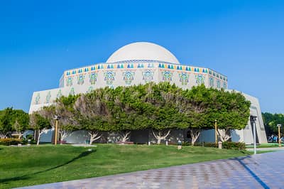 National Theatre Abu Dhabi with decorative facade and green lawn.