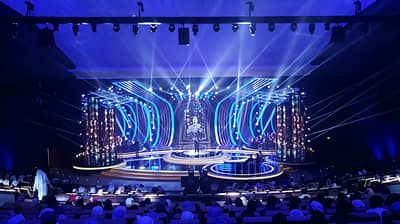 National Theatre Abu Dhabi stage with vibrant blue lighting effects.