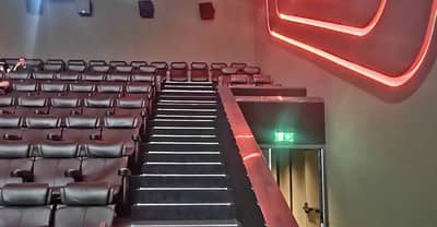 Empire Cinema Al Ahsa seating with illuminated exit sign, Al Hofuf.
