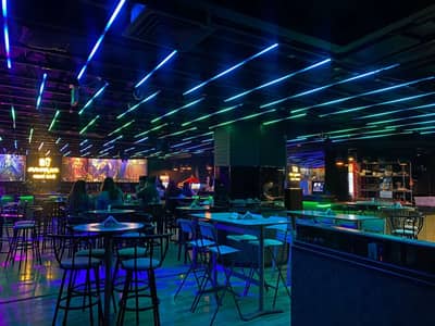 Maharlika Night Club Doha with colorful neon lights and seating.