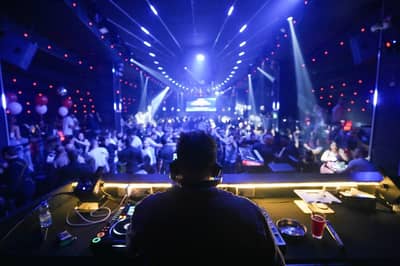 DJ performing at OX Club Doha with vibrant crowd and lights.