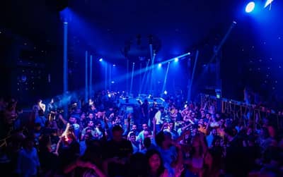 Crowded nightclub with blue lighting at OX Club Doha.