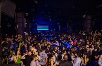 Crowded nightclub scene at OX Club Doha with lively atmosphere.