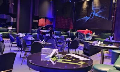 Matrix Club Qatar lounge area with tables and blue lighting, Doha.
