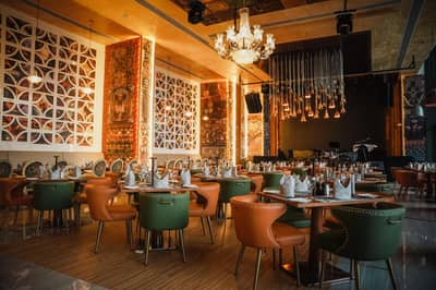 Elegant dining area at Tanatan Dubai with chandeliers and colorful decor.