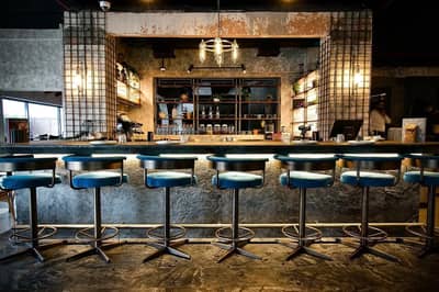 Stylish bar interior at 11 Woodfire Restaurant, Dubai.