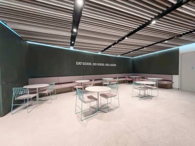 Modern seating area with round tables at Terra, Expo City Dubai, UAE.