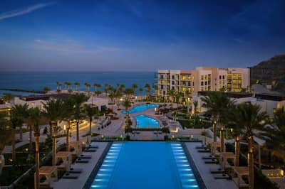Illuminated pool and resort buildings at Address Beach Resort Fujairah, Fujairah, UAE