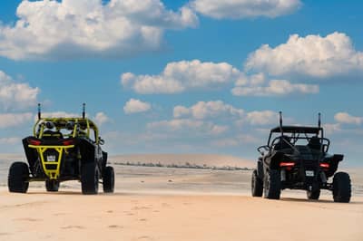 Two off-road vehicles on desert terrain at The Outpost Al Barari, Doha, QATAR.