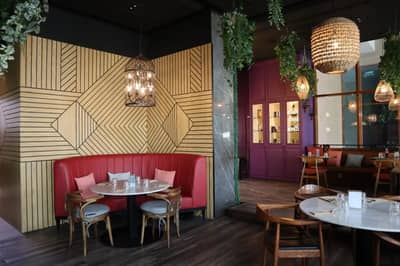 Stylish dining area with red booth seating at Ella's Eatery Restaurant Dubai, UAE.
