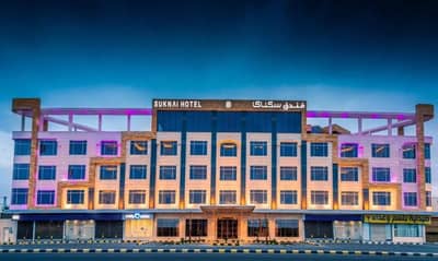 Illuminated exterior of Sukani Royal Hotel Hail, Hail, Saudi Arabia at night.