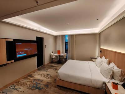 Modern guest room with bed and TV at Ayas Hotel Hail, Saudi Arabia.
