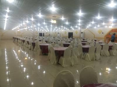 Spacious event hall with round tables at Andalus Palace for Wedding Makkah.