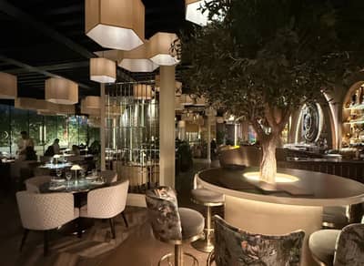 Elegant dining area with tree centerpiece at The Banc Dubai, Dubai, UAE.