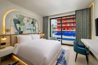 Luxurious guest room with pool view at Voco Dubai Nice The Heart of Europe.