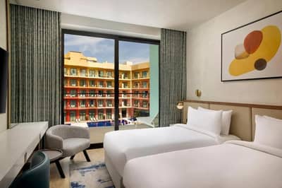 Guest room with twin beds at Voco Dubai Nice The Heart of Europe, Dubai.