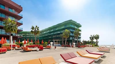 Outdoor seating and palm trees at Voco Dubai Nice The Heart of Europe, Dubai.