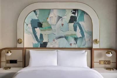 Elegant guest room with abstract headboard at Voco Dubai Nice, Dubai, UAE.
