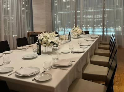 Elegant dining setup with floral centerpieces at Estiatorio Milos Dubai, UAE.
