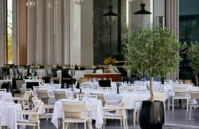 Elegant dining setup with white tablecloths at Estiatorio Milos Dubai, UAE