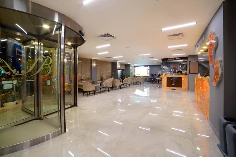 Hotel Bulvar Palas - a large lobby with a waiting area with tables and chairs at Hotel Bulvar Palas in Istanbul