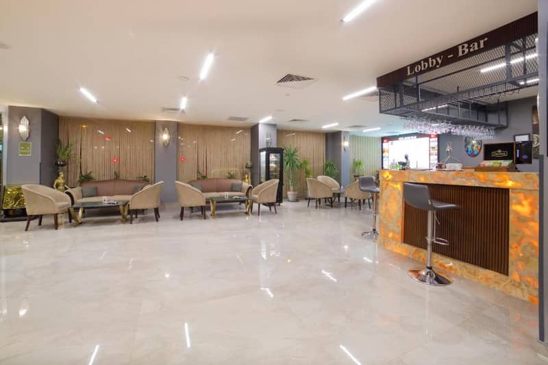 Hotel Bulvar Palas - a lobby of a hotel with tables and chairs at Hotel Bulvar Palas in Istanbul