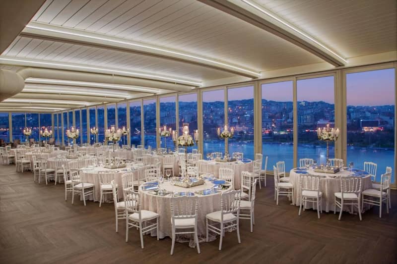 Lazzoni Hotel - a banquet hall with white tables and chairs and windows at Lazzoni Hotel in Istanbul