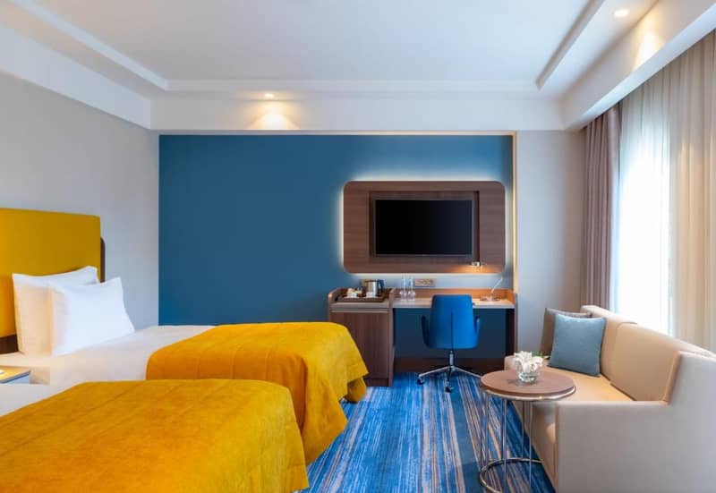 Mövenpick Hotel Istanbul Asia Airport - a hotel room with two beds and a flat screen tv at Mövenpick Hotel Istanbul Asia Airport in Istanbul