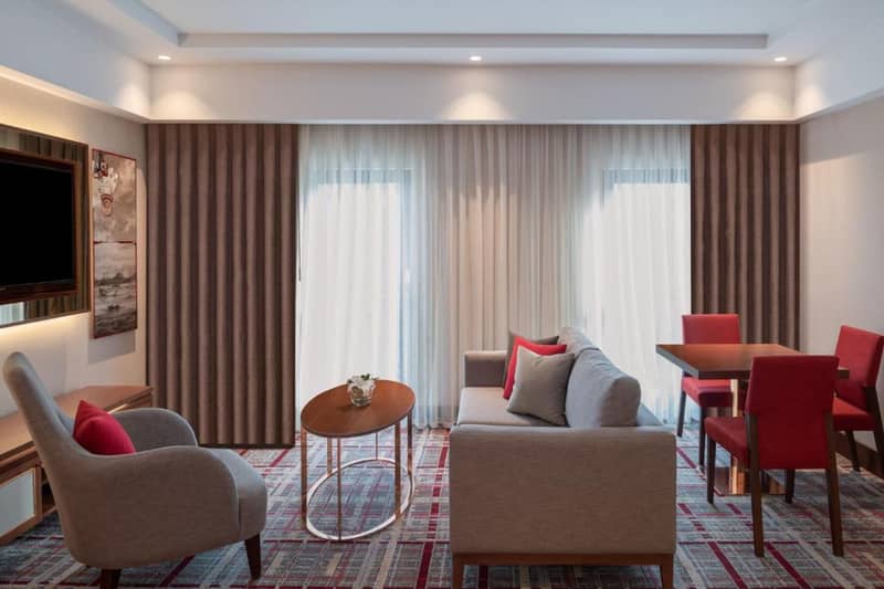Mövenpick Hotel Istanbul Asia Airport - a hotel room with a couch and chairs and a table at Mövenpick Hotel Istanbul Asia Airport in Istanbul