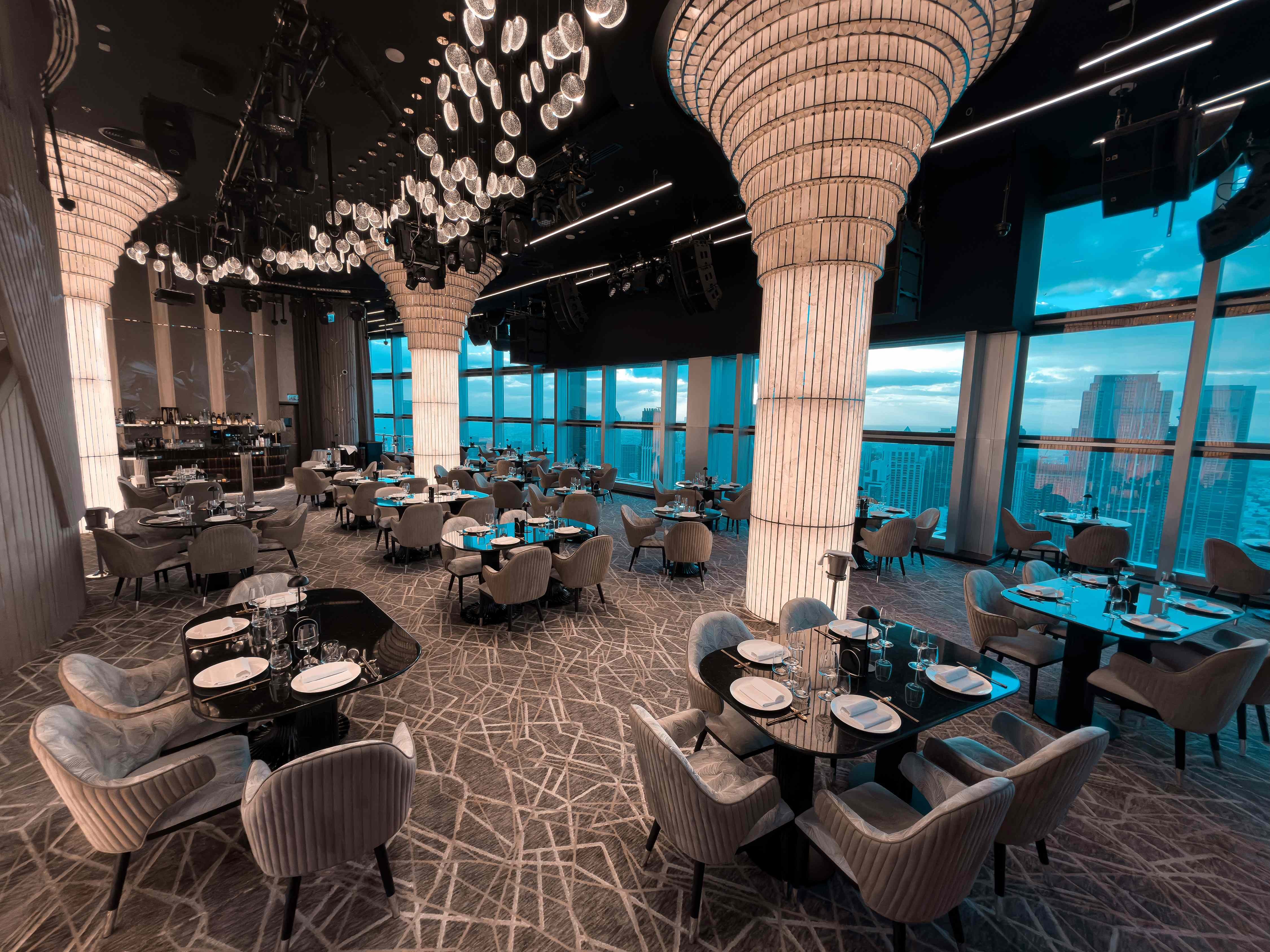 Elegant dining setup at Birds Restaurant, Dubai with city skyline view.