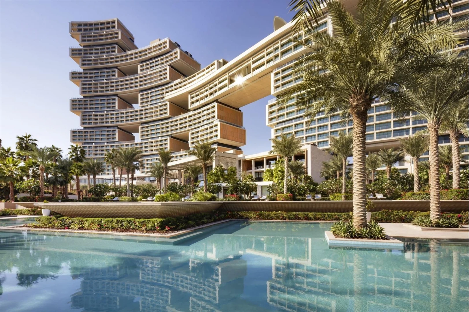 Atlantis The Royal Dubai with pool and palm trees.
