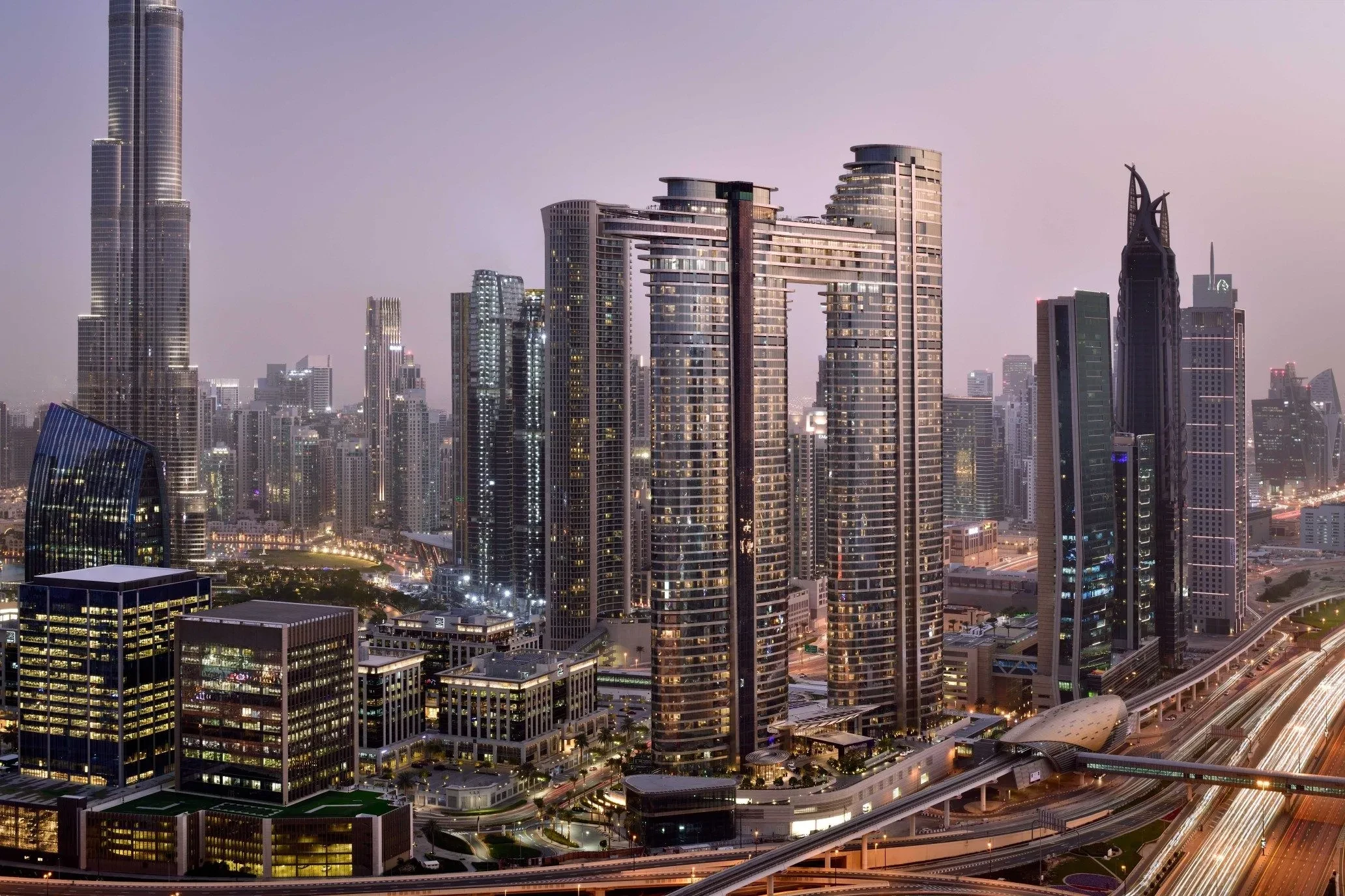 Address Sky View towers in Dubai skyline at dusk.